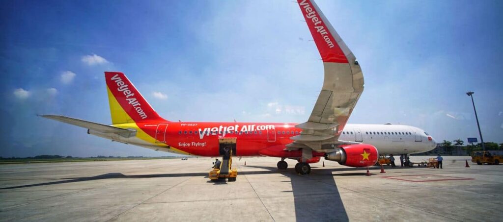 VietJet Air narrow-body aircraft parked on the apron with red and yellow livery and VietJetAir.com visible on the fuselage.