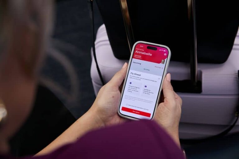 Hands holding a phone displaying a travel app profile for Annabelle with upcoming flights.
