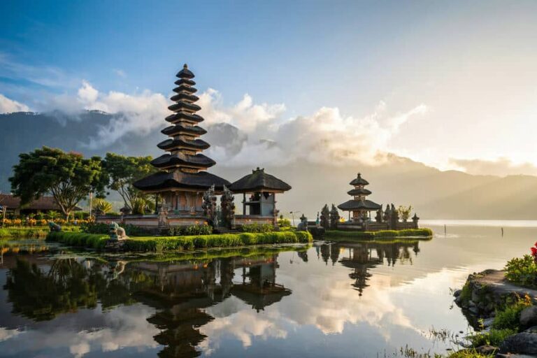 Multi-tier pagoda temple on a calm lake with mountains in the background (Balinese water temple).