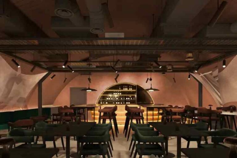 Warm, modern restaurant interior with a curved, backlit bar and wooden stools as multiple tables sit in the foreground.