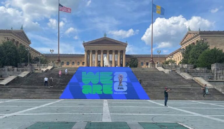 Blue promotional stage on the Philadelphia Museum of Art stairs reading 'WE ARE' with FIFA World Cup trophy logo.